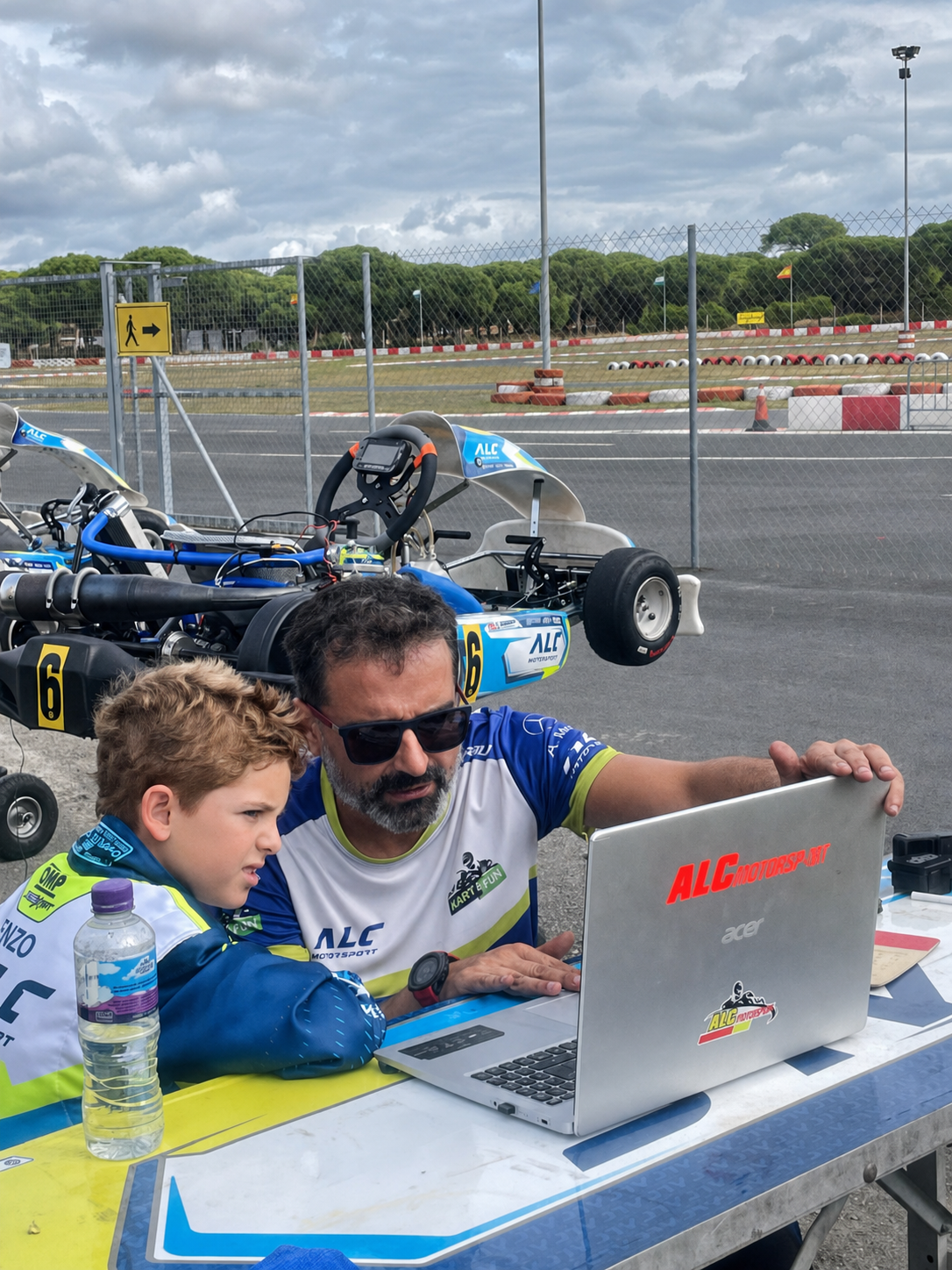 Coach de ALC Motorsport trabajando con un joven piloto durante el análisis de una sesión de karting.